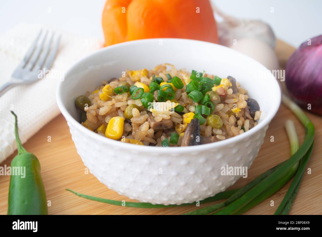 Chinese style vegetarian egg fried rice with sweet corn, green peas, onions, garlic, mushrooms and scallions Stock Photo