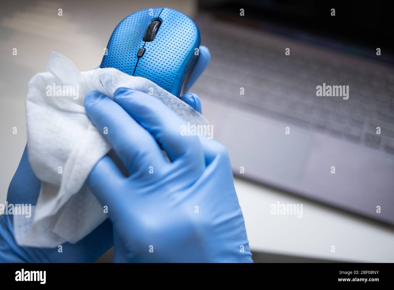 Office sanitizing wipe wiping mouse and mousepad with disinfecting wipes. Coronavirus COVID19