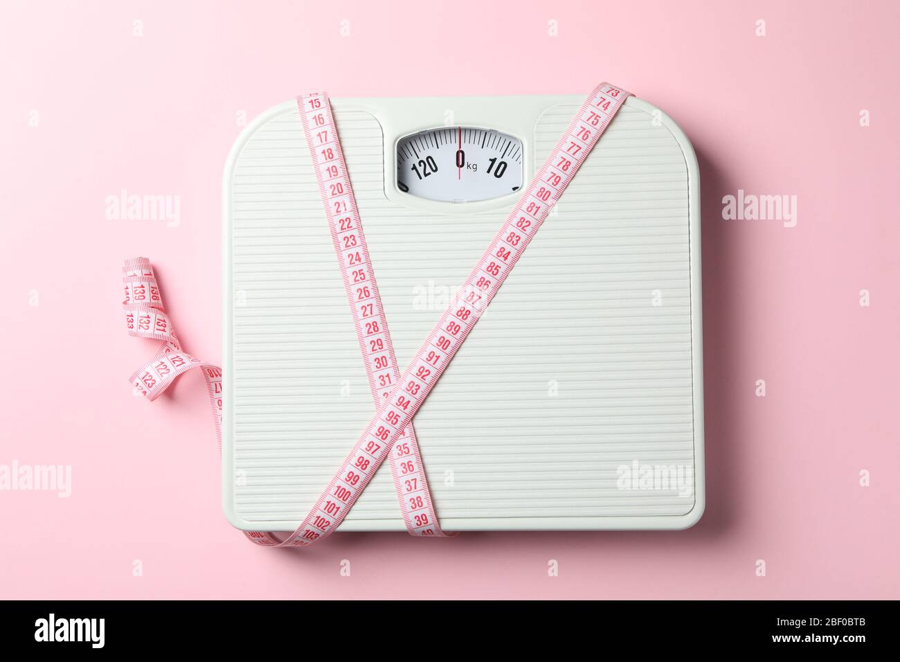 https://c8.alamy.com/comp/2BF0BTB/scales-and-measuring-tape-on-pink-background-weight-loss-concept-2BF0BTB.jpg