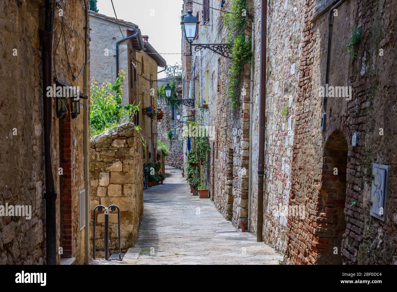 Colle di Val d'Elsa, Tuscany / Italy: A picturesque narrow curving alley with typical local houses in the historic upper town Colle Alta. Stock Photo