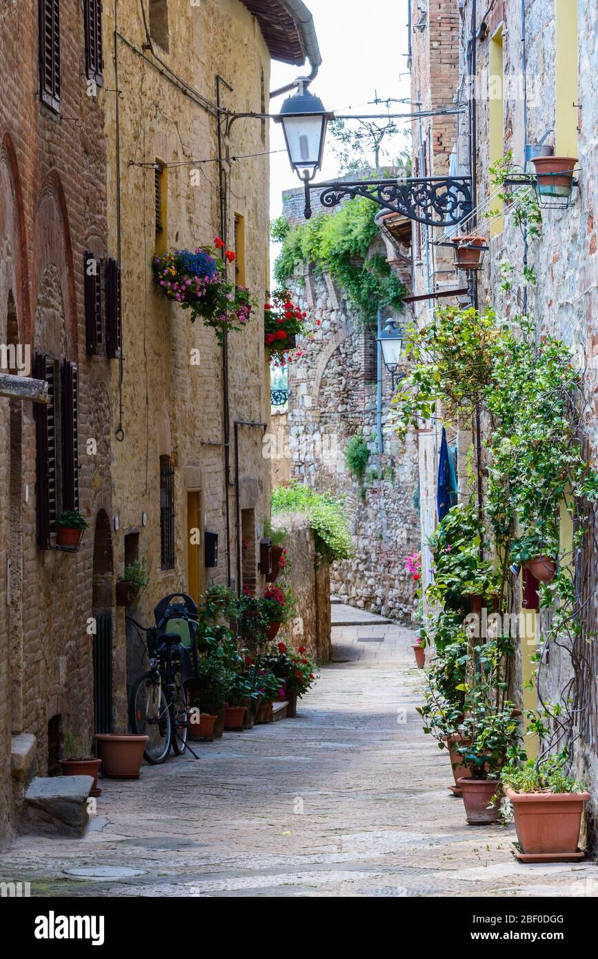 Colle di Val d'Elsa, Tuscany / Italy: A picturesque narrow curving alley with typical local houses in the historic upper town Colle Alta. Stock Photo