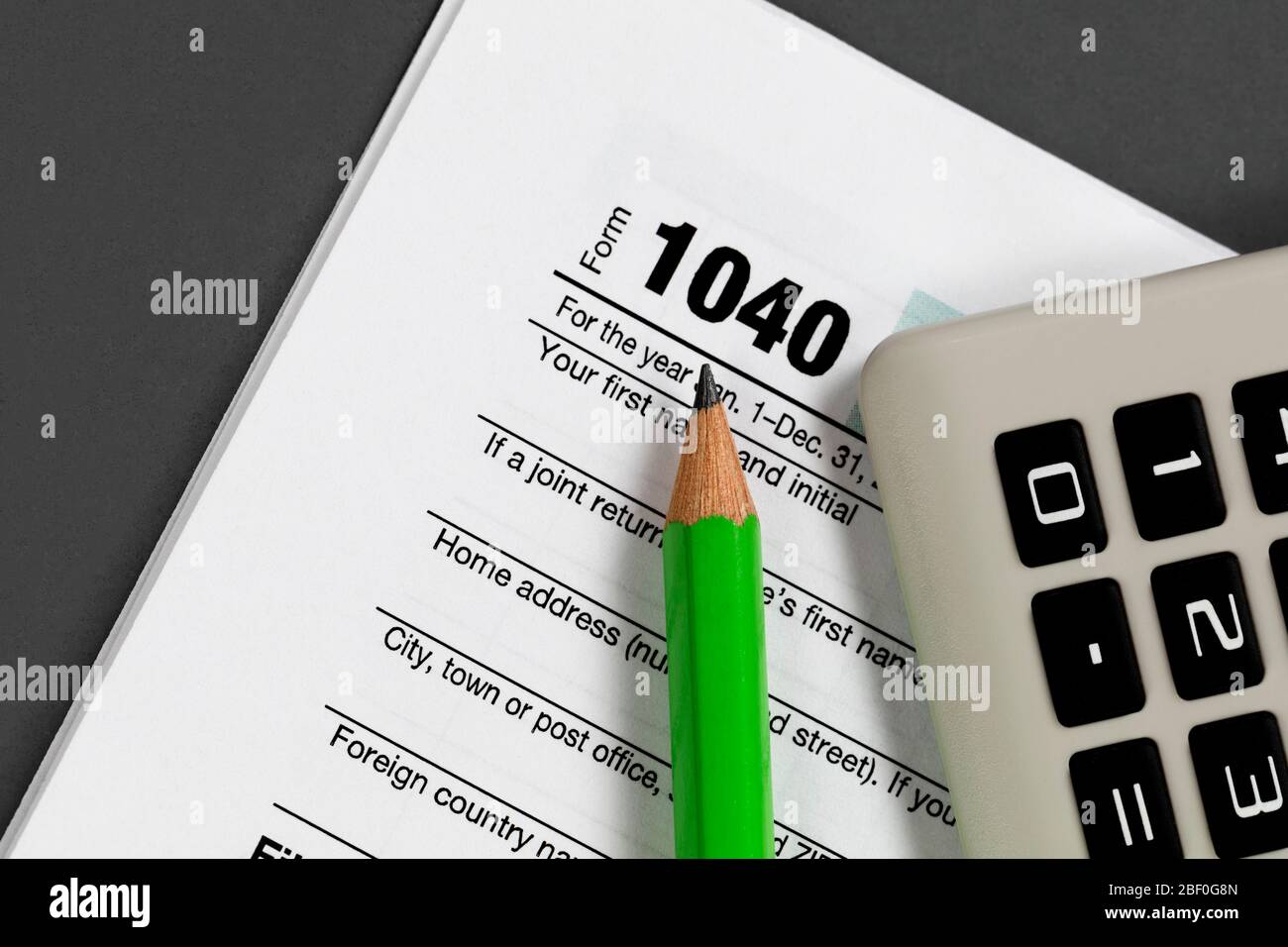 Close up of pencil tip with small calculator and standard 1040 tax form Stock Photo