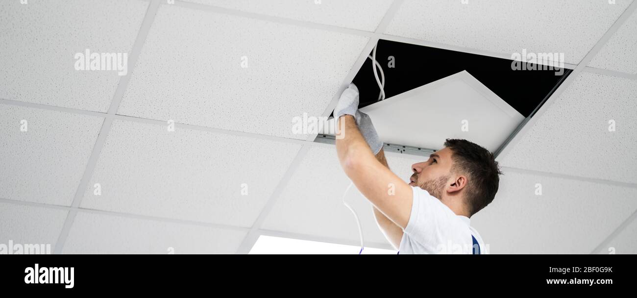 Electrician On Ladder Installing Office Lights On Ceiling Stock Photo ...