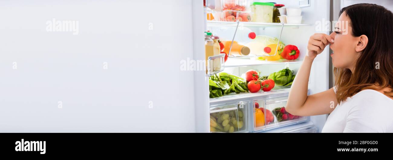 Refrigerator Bad Rotten Smell. Woman Smelling Rotten Fruit Stock Photo