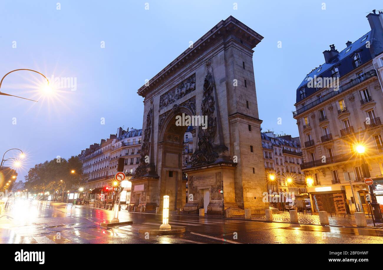 The Porte Saint-Denis triumphal arch at rainy night , Paris, France ...