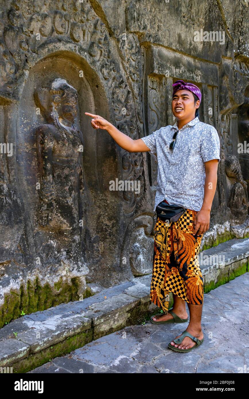 Vertical portrait of a local tour guide at Yeh Pulu Relief in Bali, Indonesia. Stock Photo