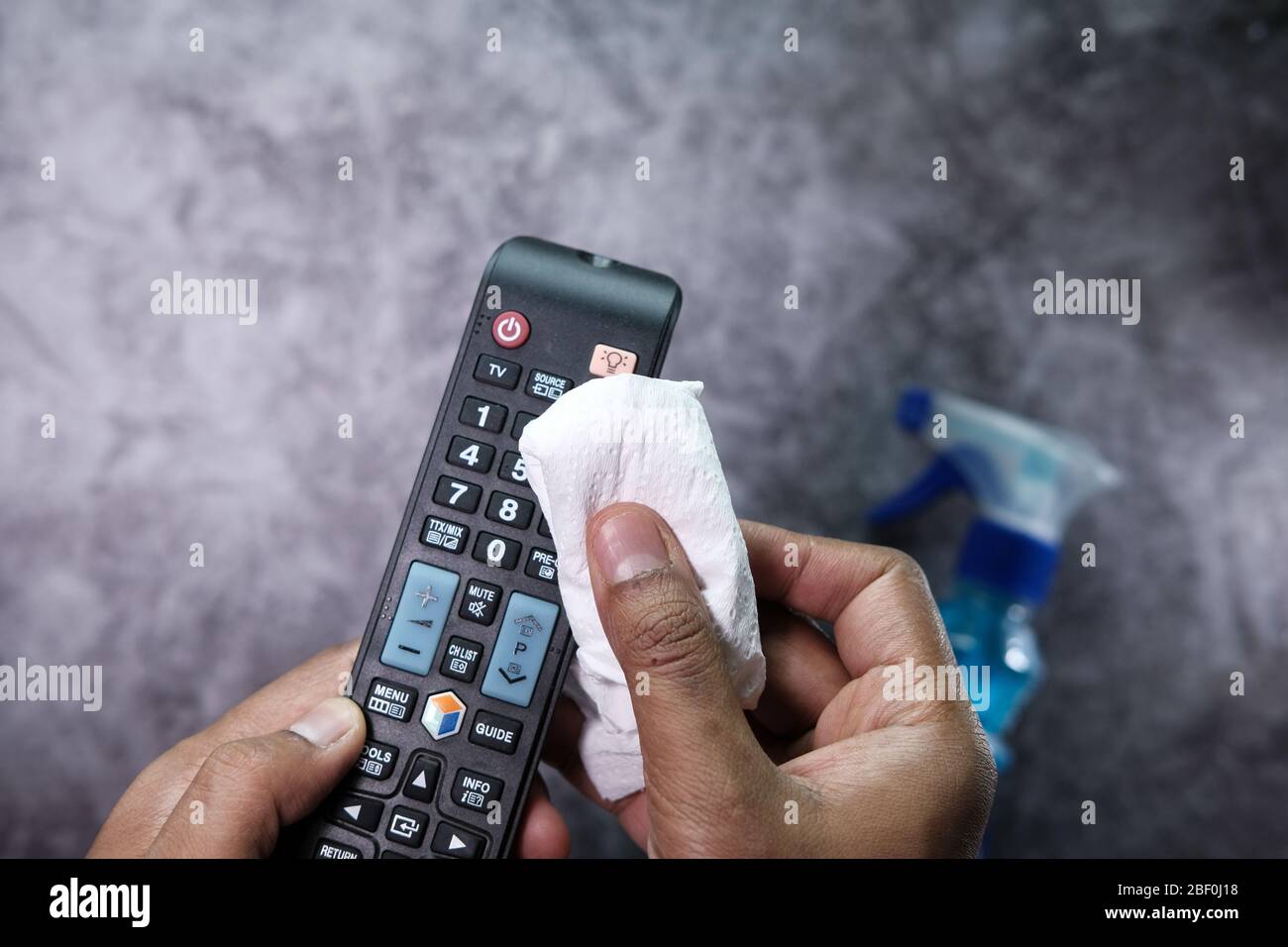 f man hand using wet wipe for disinfecting TV remote control Stock