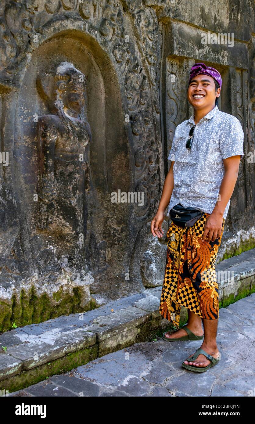 Vertical portrait of a local tour guide at Yeh Pulu Relief in Bali,  Indonesia Stock Photo - Alamy