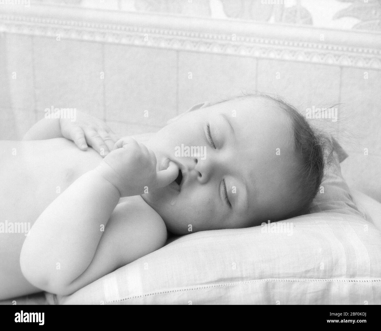 1920s 1930s PEACEFULLY SLEEPING BABY WITH INDEX FINGER IN MOUTH - b220 HAR001 HARS RELAXATION REST BABY GIRL BLACK AND WHITE CAUCASIAN ETHNICITY HAR001 OLD FASHIONED Stock Photo