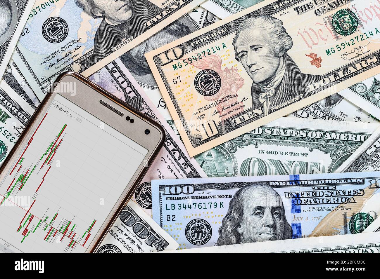 Concept with money american dollar bills and mobile phone with the schedule of exchange rates. Cash dollars. Stock Photo