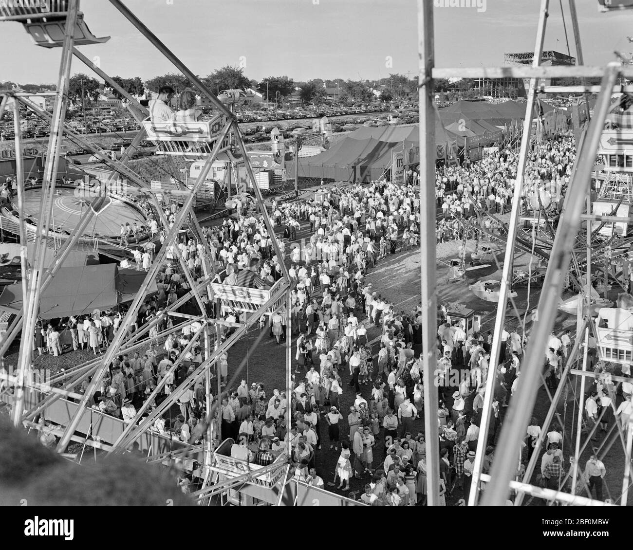 1940s ELEVATED VIEW PHOTOGRAPHED FROM FERRIS WHEEL OF PEOPLE ATTENDING STATE FAIR ST PAUL MINNESOTA USA - f1254 HAR001 HARS FEMALES ASSEMBLY UNITED STATES COPY SPACE LADIES MASS PERSONS UNITED STATES OF AMERICA MALES CARNIVAL ENTERTAINMENT PAUL SPECTATORS B&W GATHERING NORTH AMERICA NORTH AMERICAN ST HIGH ANGLE ADVENTURE DISCOVERY LEISURE EXCITEMENT RECREATION OPPORTUNITY FERRIS TENTS ELEVATED MIDWAY ATTENDING JUVENILES PHOTOGRAPHED RIDES THRONG AMUSEMENT PARK ATTENDANCE BLACK AND WHITE HAR001 MINNESOTA OLD FASHIONED THEME PARK Stock Photo