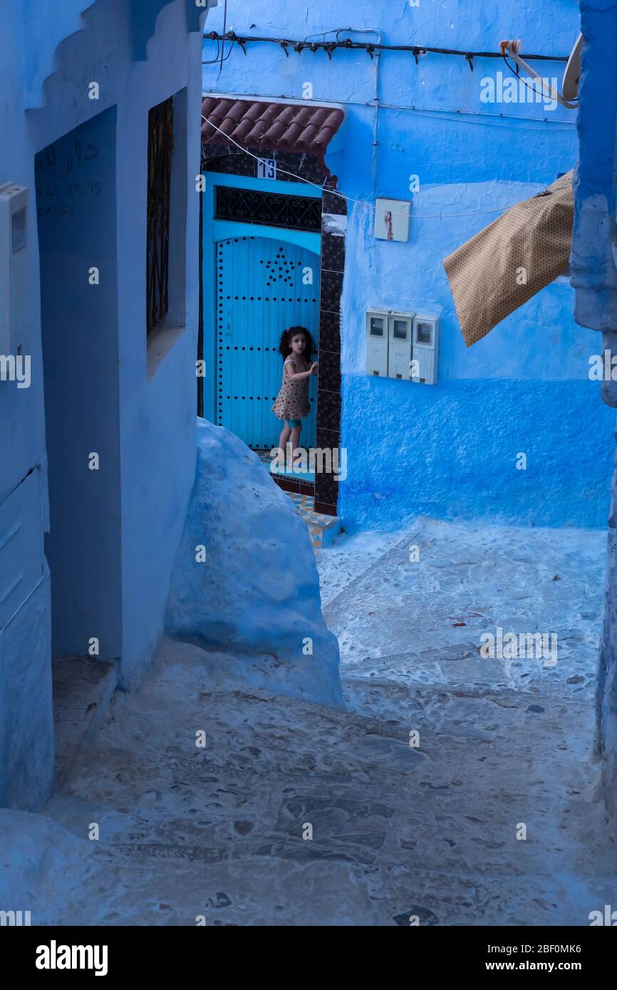 Chefchaouen, the blue city, northern Morocco, June 10, 2016. A child outside his house, observes. Stock Photo