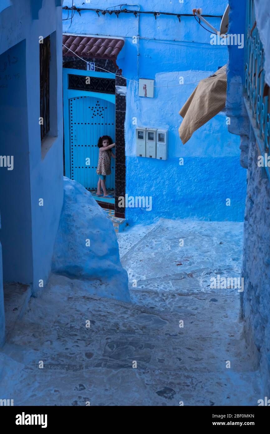 Chefchaouen, the blue city, northern Morocco, June 10, 2016. A child outside his house, observes. Stock Photo