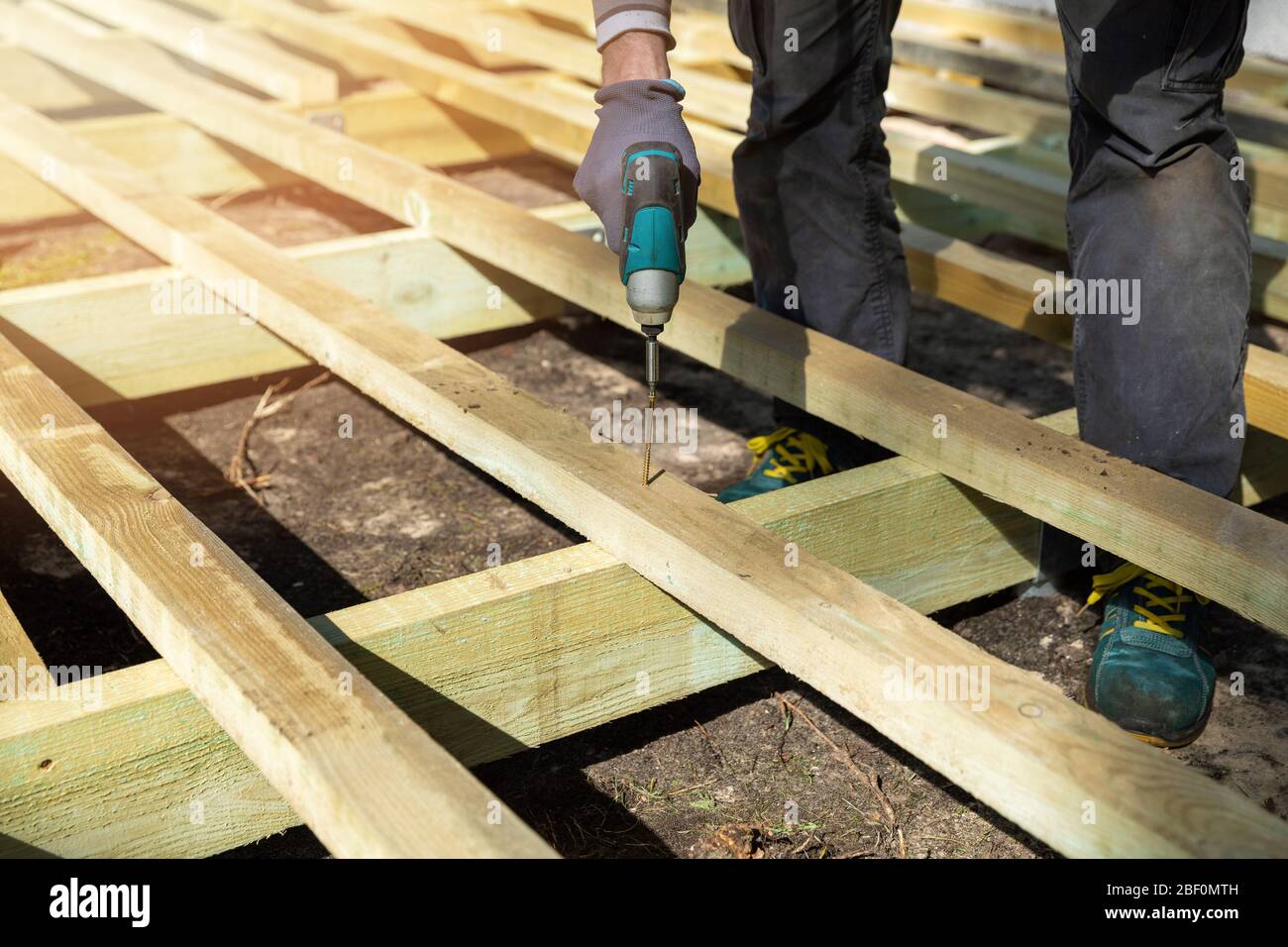 man building wooden frame for patio deck Stock Photo