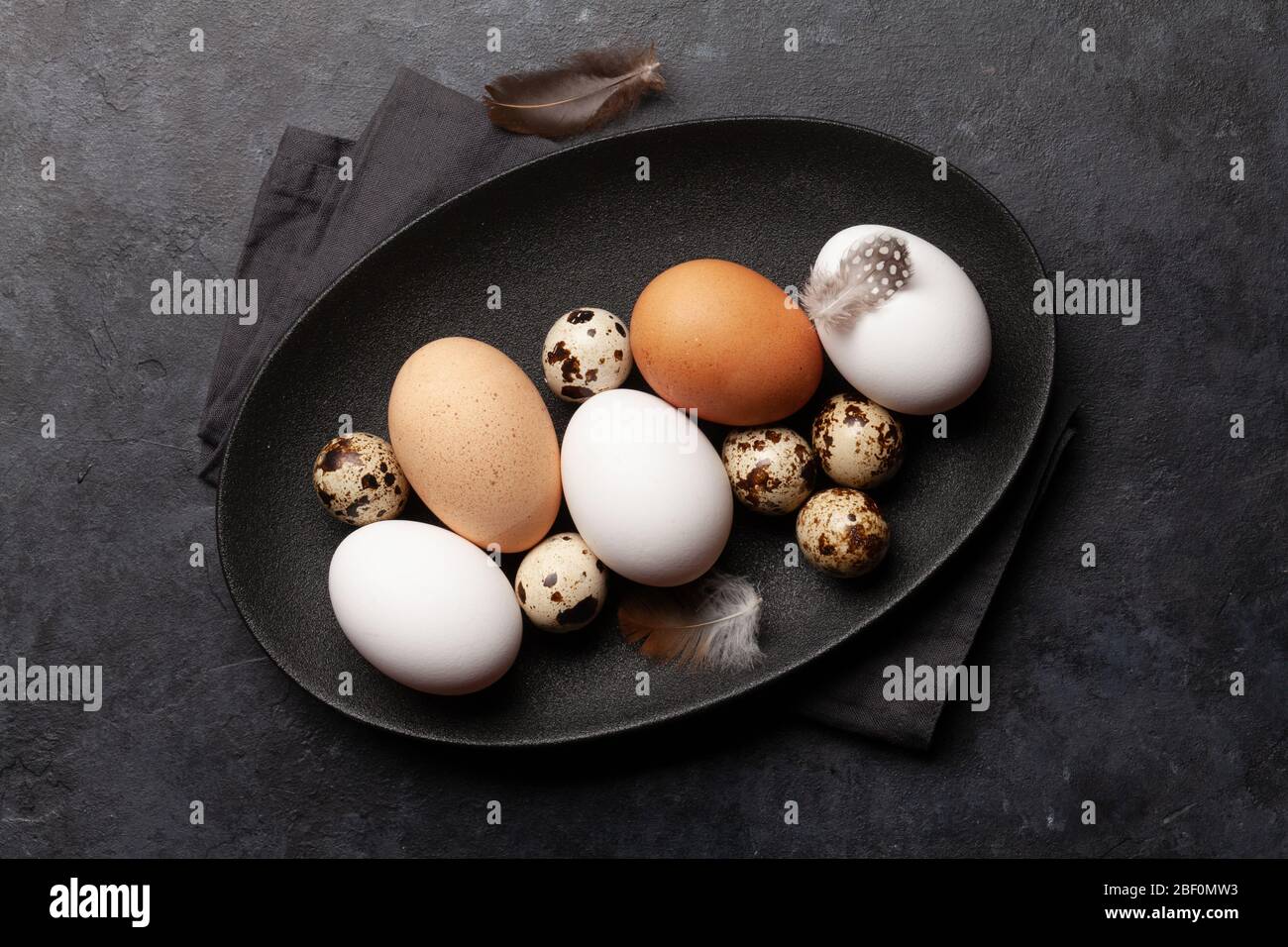 White, brown and quail eggs on stone table. Top view. Flat lay Stock Photo