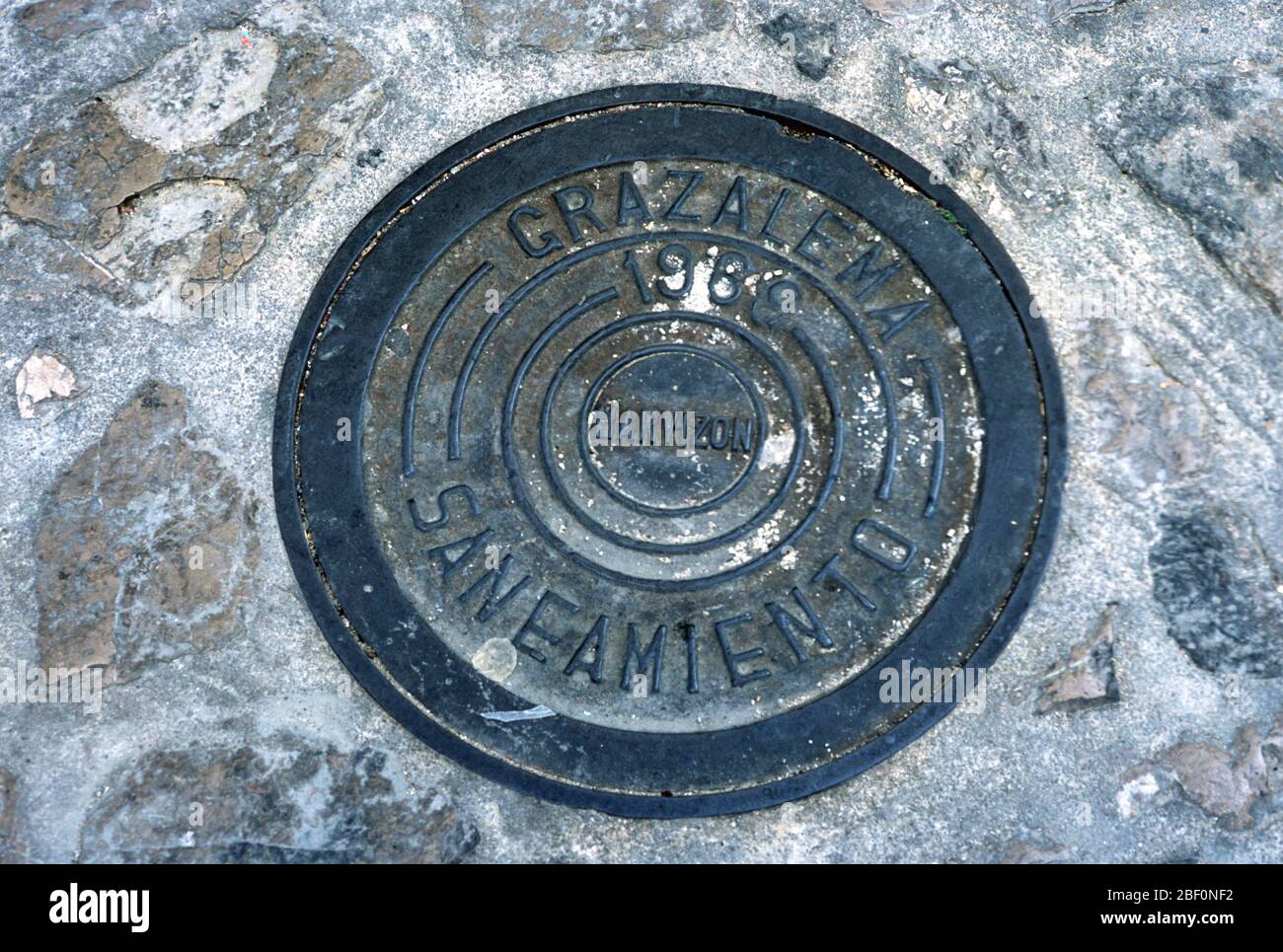 Embossed drain cover set in a cobbled street in Grazalema, Cadiz, Andalucia, Spain Stock Photo