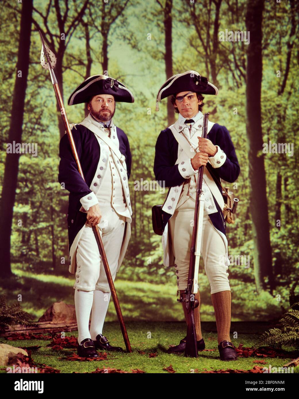 1970s TWO MEN RE-ENACTORS IN AMERICAN REVOLUTION CONTINENTAL ARMY UNIFORMS ONE HOLDING A SPONTOON AND OTHER A FLINTLOCK MUSKET  - kc6820 HAR001 HARS HISTORY STUDIO SHOT REVOLUTIONARY COPY SPACE FRIENDSHIP FULL-LENGTH PERSONS MALES EYE CONTACT FREEDOM WARS ADVENTURE AND TRICORN CONTINENTAL A IN 1776 FLINTLOCK POLITICS UNIFORMS WAR OF INDEPENDENCE CONNECTION RE-ENACTORS MUSKET REVOLT AMERICAN REVOLUTIONARY WAR 1770s COLONIES FIREARM FIREARMS MID-ADULT MID-ADULT MAN SPONTOON CAUCASIAN ETHNICITY ESPONTOON HALF-PIKE HAR001 MINUTEMEN OLD FASHIONED Stock Photo