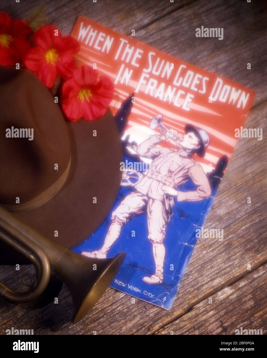 1919 WORLD WAR I STILL LIFE BUGLE, SOLDIER’S HAT POPPIES AND SHEET MUSIC OF WHEN SUN GOES DOWN IN FRANCE WITH DRAWING OF SOLDIER - ks17722 HAR001 HARS UNIFORMS MUSICAL INSTRUMENT CAMPAIGN CONCEPTUAL STILL LIFE PATRIOTIC BUGLE WORLD WAR ONE WW1 GOES HAR001 OLD FASHIONED Stock Photo