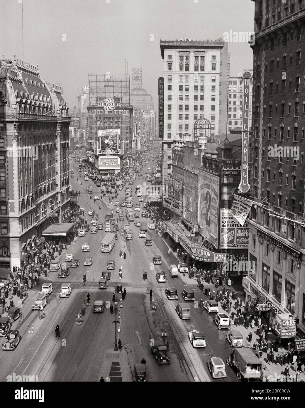 1930s NEW YORK CITY  TIMES SQUARE LOOKING NORTH UP BROADWAY TO DUFFY SQUARE FROM ORIGINAL TIMES TOWER SEEN AS A SHADOW - q45982 CPC001 HARS PERSONS INSPIRATION UNITED STATES OF AMERICA AUTOMOBILE MALES PEDESTRIANS ENTERTAINMENT TRANSPORTATION B&W TOWER DREAMS MIDTOWN HIGH ANGLE ADVENTURE AUTOS EXTERIOR GOTHAM OPPORTUNITY UP NYC HOTEL ASTOR ORIGINAL NEW YORK AUTOMOBILES CITIES VEHICLES NEW YORK CITY TIMES SQUARE BROADWAY THEATER DISTRICT THEATERS BIG APPLE BLACK AND WHITE DUFFY GREAT WHITE WAY OLD FASHIONED Stock Photo
