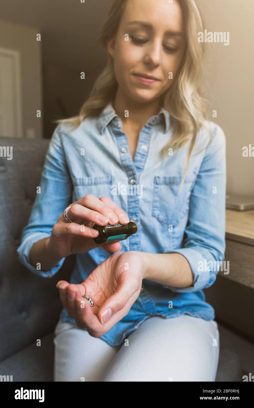 Young woman applying essential oils to her wrist Stock Photo
