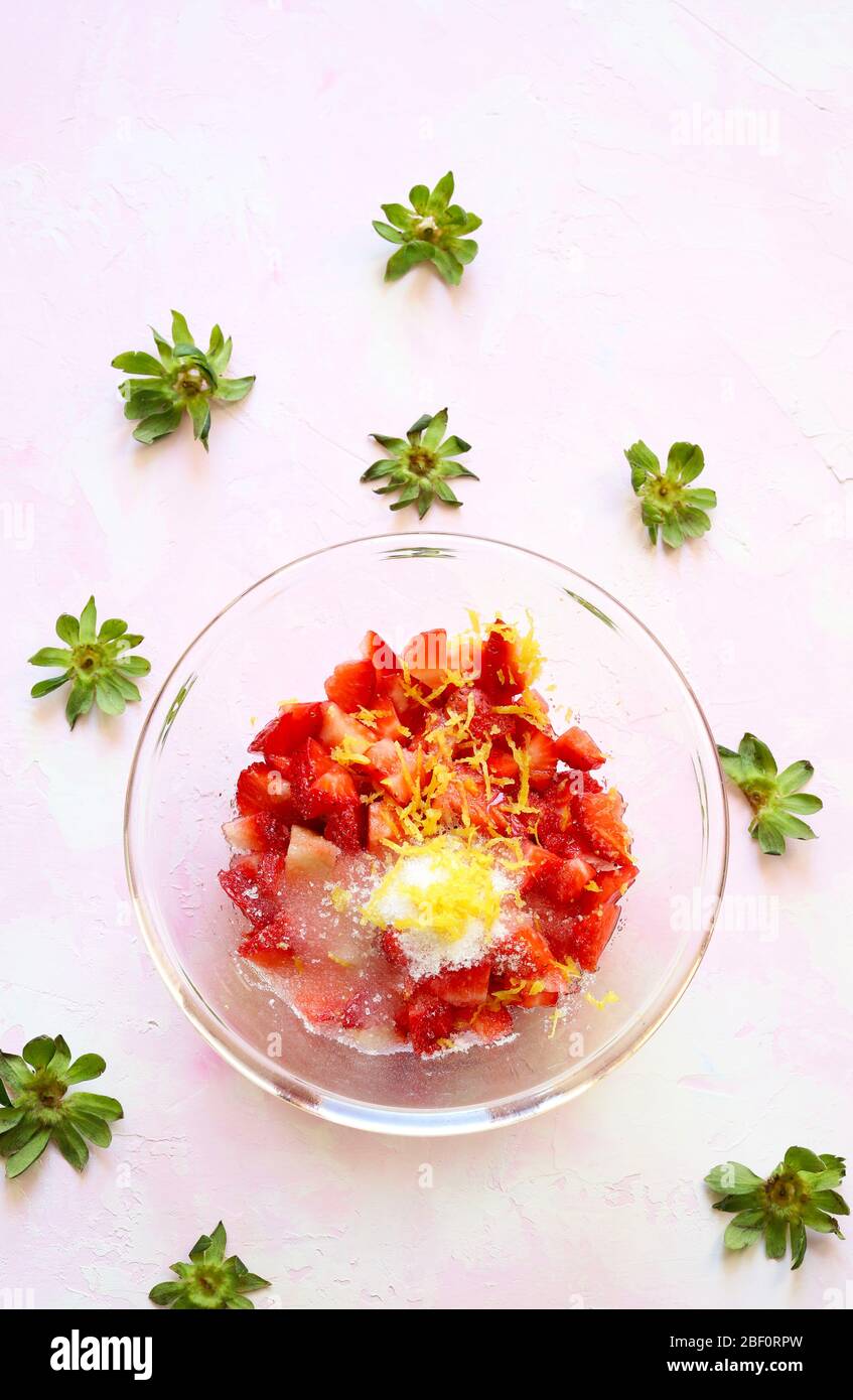 Fresh organic red strawberries in glass bowl with sugar and lemon ...