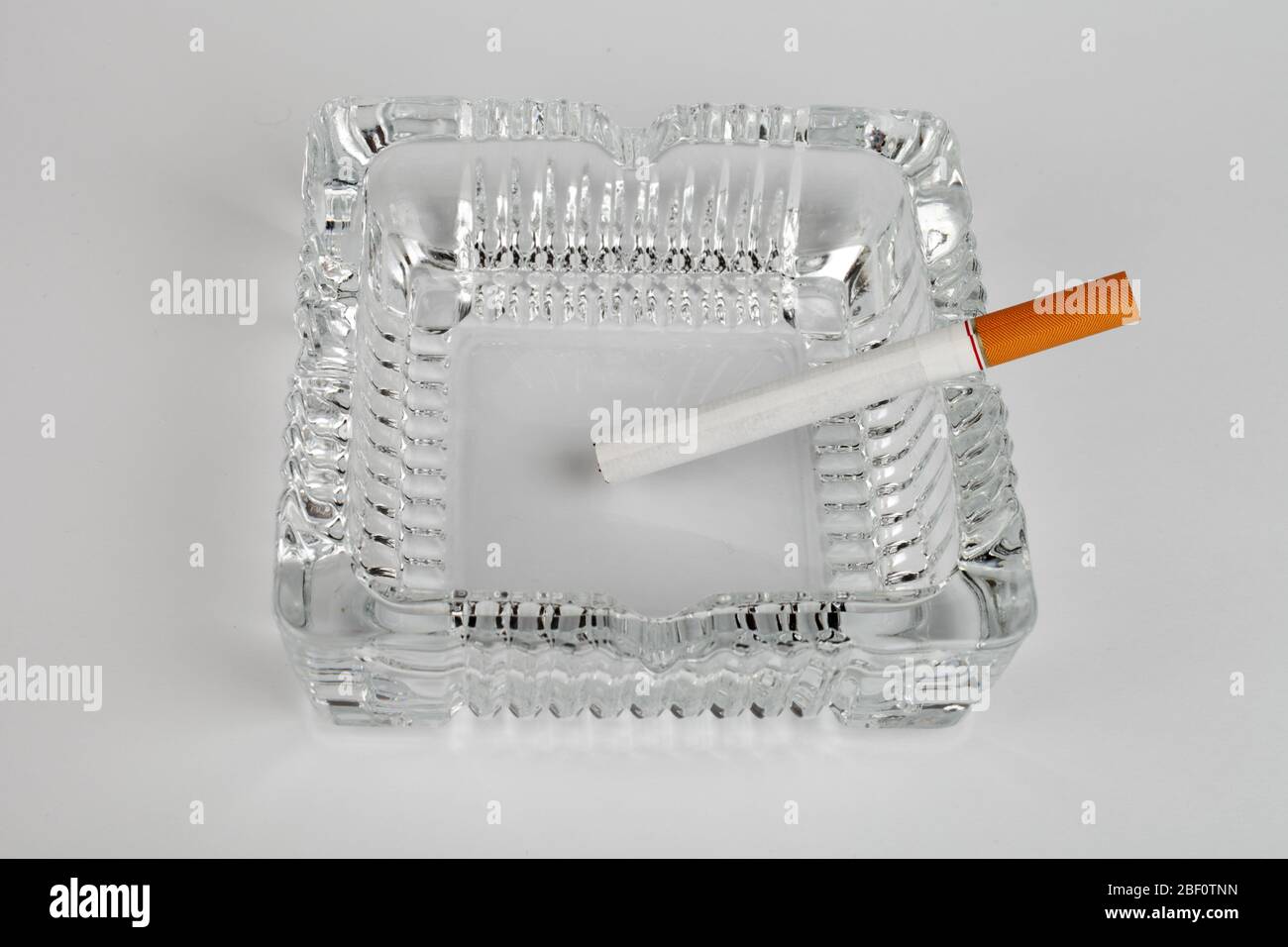 crystal square ashtray with cigarette on a white background, isolate Stock Photo