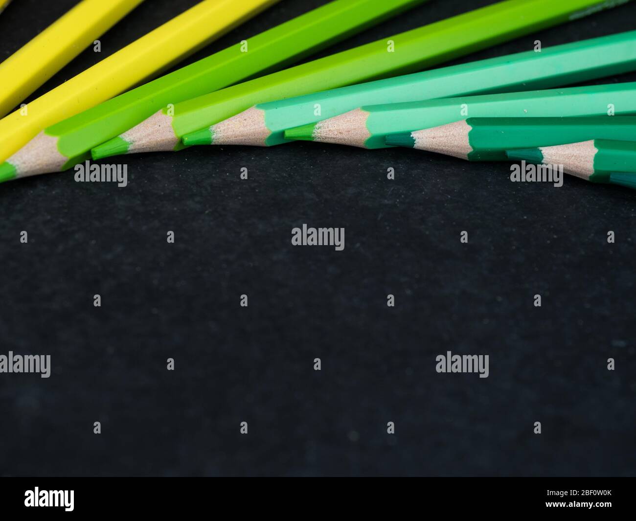 Set of colored pencils arranged in a wheel on slate background. close up Stock Photo