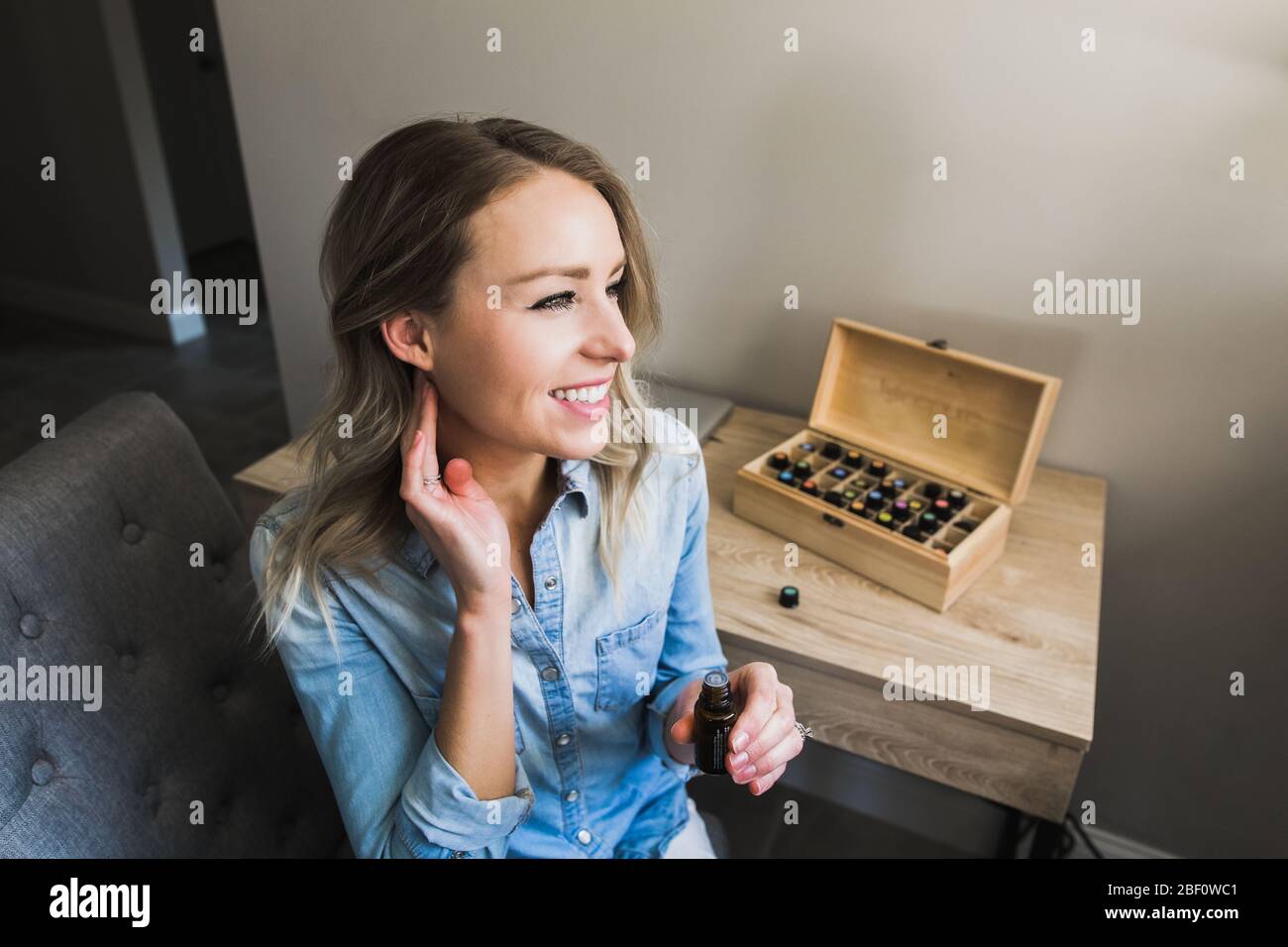Young woman applying essential oils to her neck Stock Photo