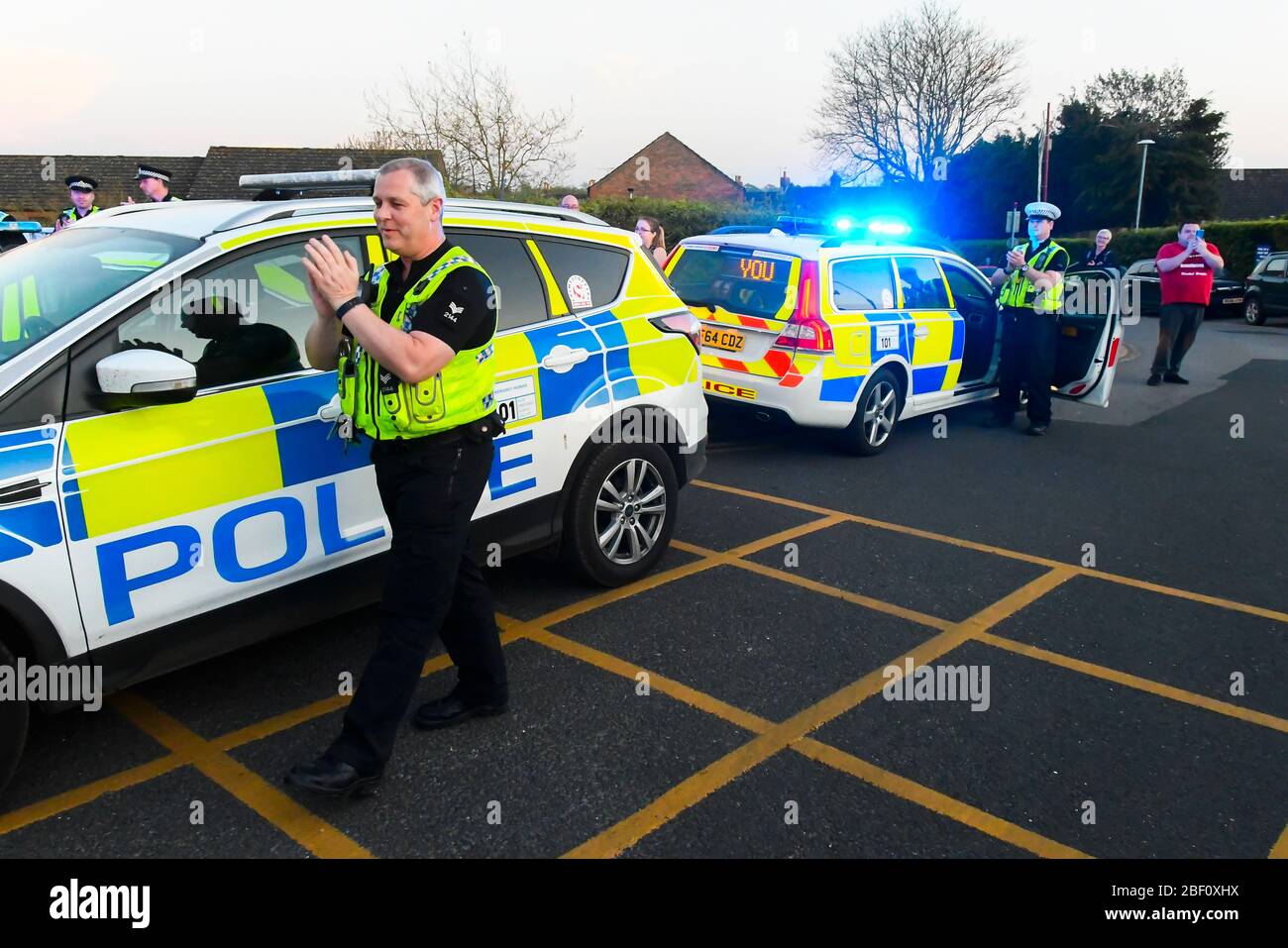 Dorchester, Dorset, UK.  16th April 2020.  Frontline staff including doctors, nurses, police and fire and rescue staff clap for carers, key workers and NHS staff outside the entrance to the A&E department at Dorset County Hospital at Dorchester in Dorset during the coronavirus pandemic lockdown.  Picture Credit: Graham Hunt/Alamy Live News Stock Photo