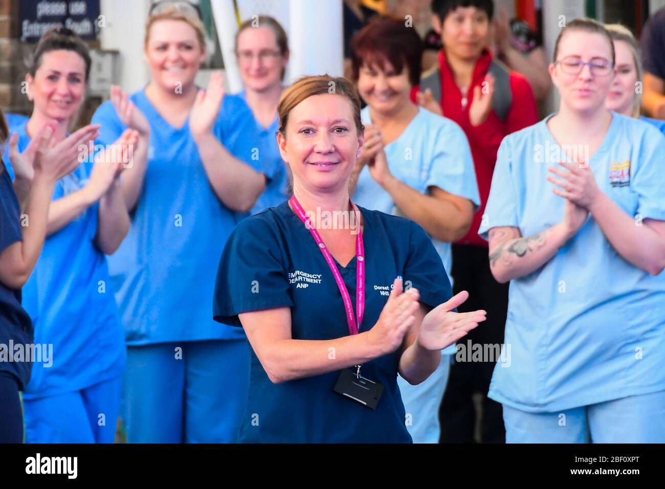 Dorchester, Dorset, UK.  16th April 2020.  Frontline staff including doctors, nurses, police and fire and rescue staff clap for carers, key workers and NHS staff outside the entrance to the A&E department at Dorset County Hospital at Dorchester in Dorset during the coronavirus pandemic lockdown.  Picture Credit: Graham Hunt/Alamy Live News Stock Photo