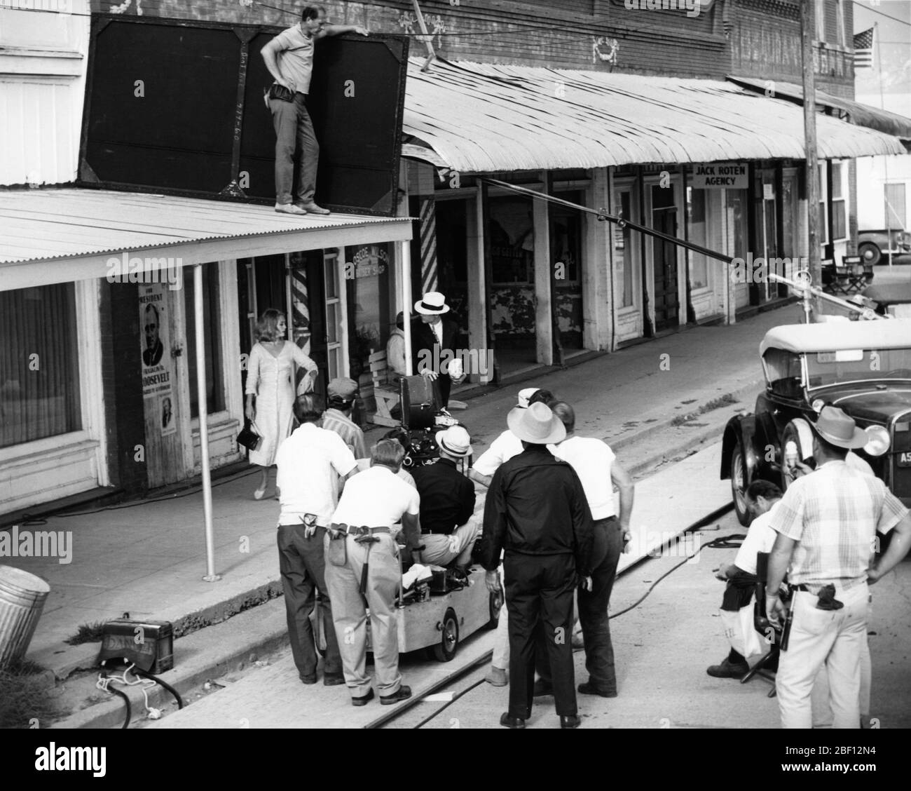 FAYE DUNAWAY as Bonnie Parker and WARREN BEATTY as Clyde Barrow on set location candid with Movie Crew in Venus, Texas filming BONNIE AND CLYDE 1967 director ARTHUR PENN writers David Newman and Robert Benton producer Warren Beatty Tatira - Hiller Productions / Warner Bros.- Seven Arts Stock Photo
