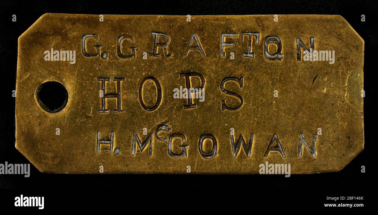 Owney tag. There is no definitive information that indicates where or when Owney received this token. The names G. Grafton and H. McGowan do not appear in the same post office together in any of the US registers of the Post Office Department during the 1890s. Stock Photo