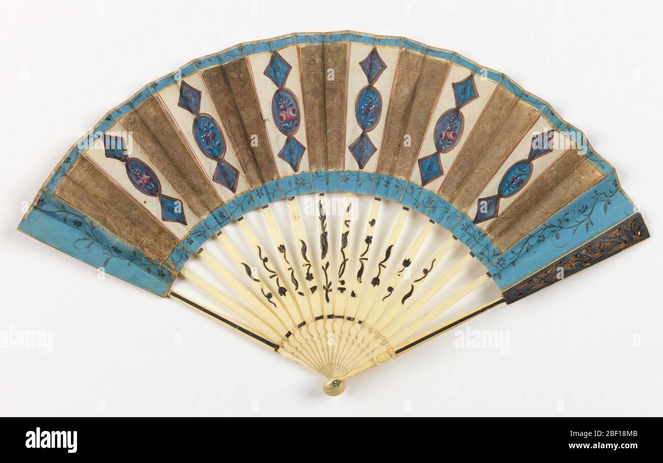 Pleated fan. Pleated fan. Front leaf of die cut and painted paper showing oval and diamond-shaped panels, back leaf of die cut paper. Sticks of ivory with applied metallic foil. Stock Photo