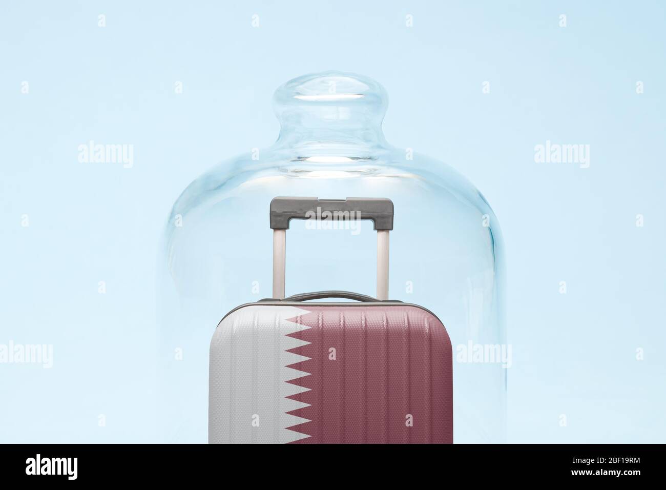 Suitcase with Qatar flag design in quarantine minimal creative coronavirus travel restriction concept. Stock Photo