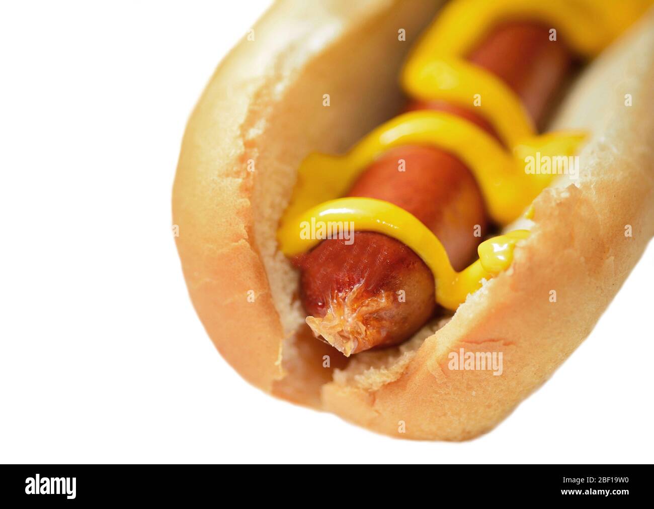 Hot dog with mustard in a plain soft bun isolated over  white background. Stock Photo