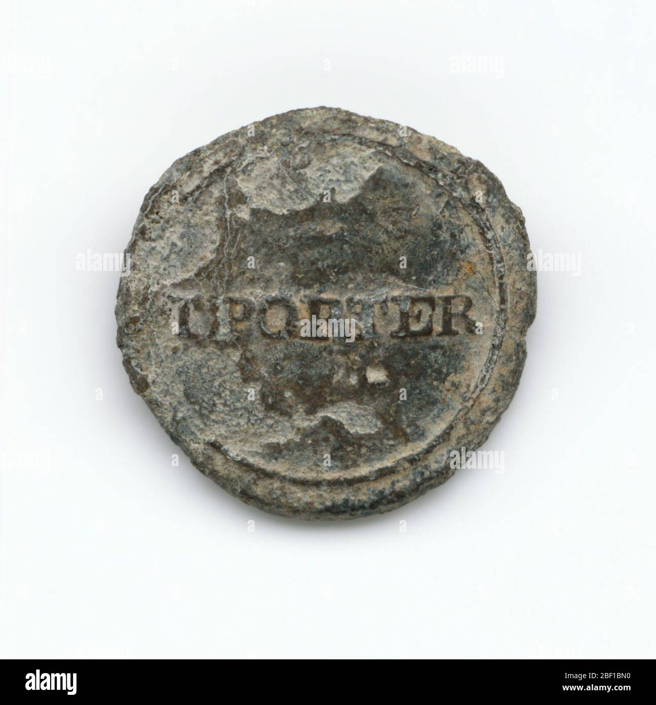 Identification button used by Thomas Porter II. A round pewter button with 'TPORTER' stamped across the middle. This button would have been sewn onto an enslaved person's shirt to identify him or her as belonging to Thomas Porter II. Stock Photo