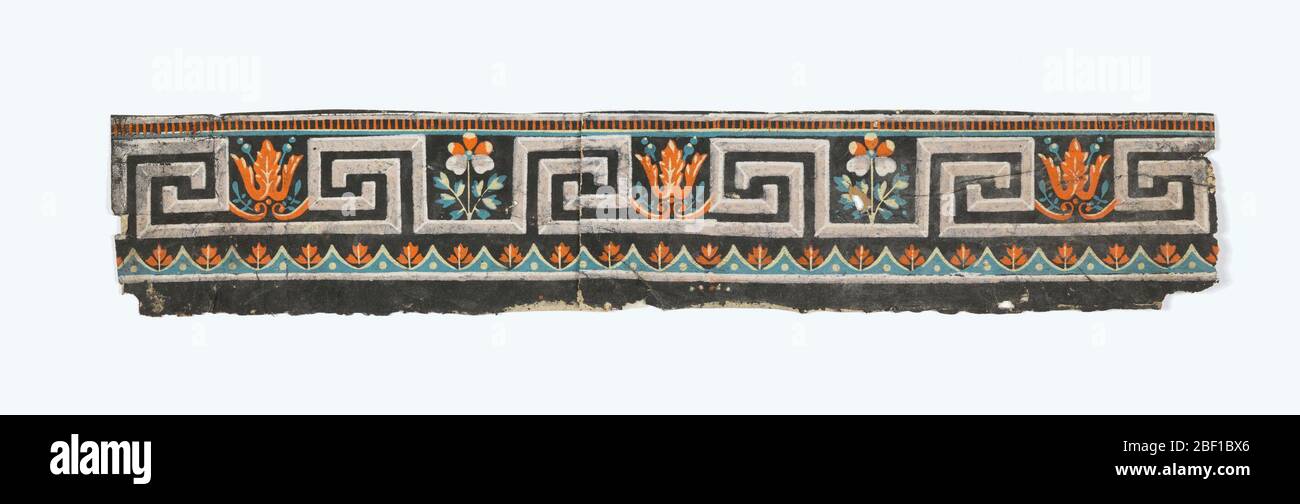 Border. Band of Greek key motif interspersed with stylized floral motifs. Printed in black, white, green and orange. Stock Photo
