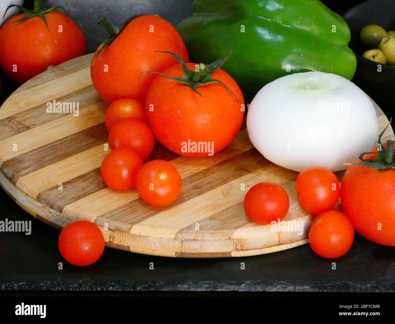 Tomatoes and vegetables on a chopping board Stock Photo - Alamy