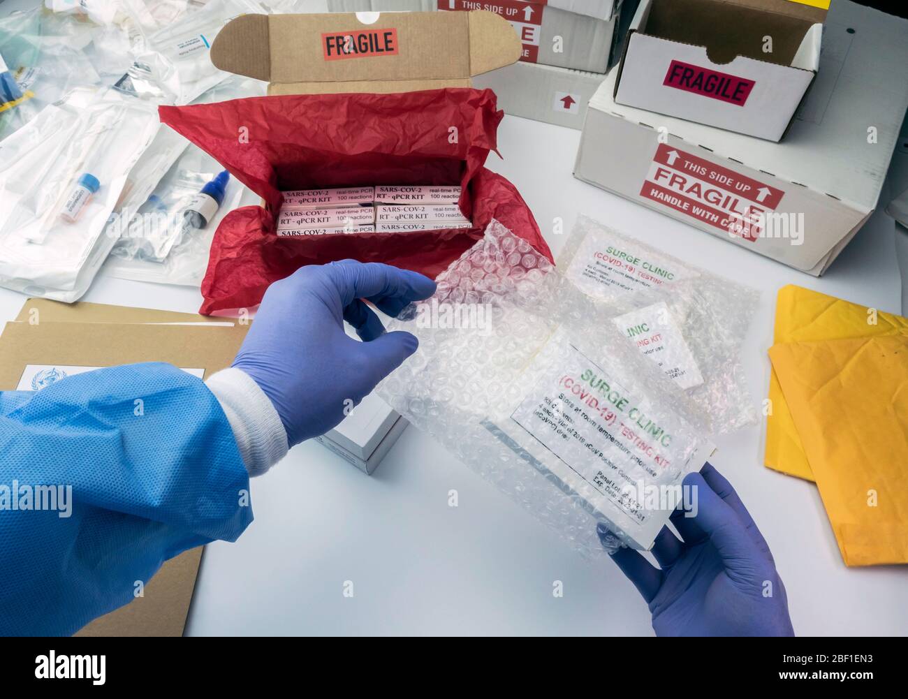 Nurse unpacking box with Covid-19 PCR kit in hospital warehouse, conceptual image Stock Photo