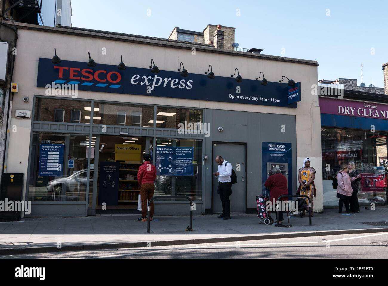 Wednesday April 15th 2020, lockdown from Corona Virus pandemic still in act. Picturing advert warning re Corona Virus restrictions around London . Part of various  location : Vauxhall, Wandsworth,  Battersea, Camden Town. Pictured : queue at Tesco express on Tower bridge road, London Stock Photo