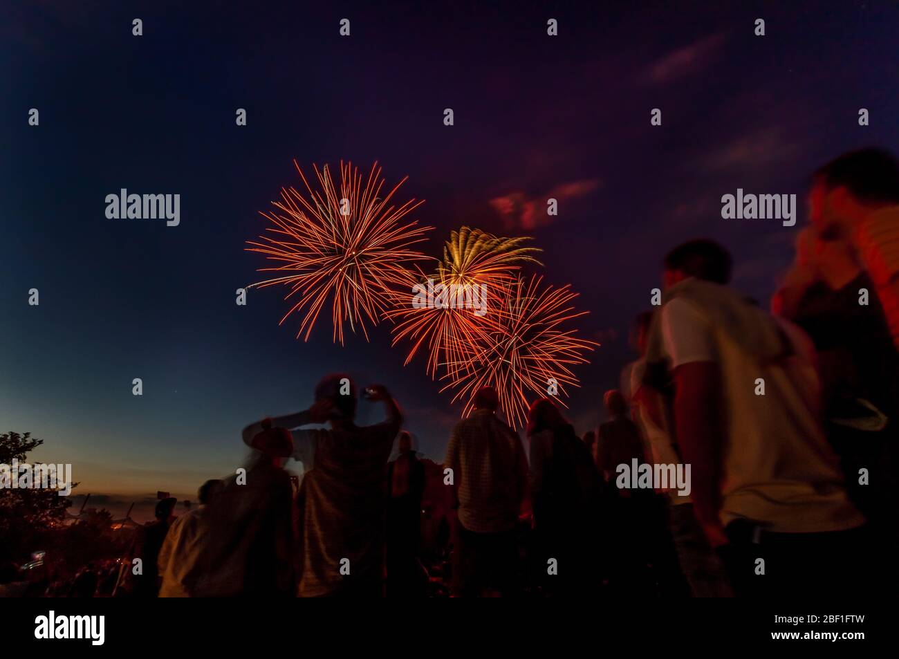 Group of people is watching an impressive firework at the night sky Stock Photo