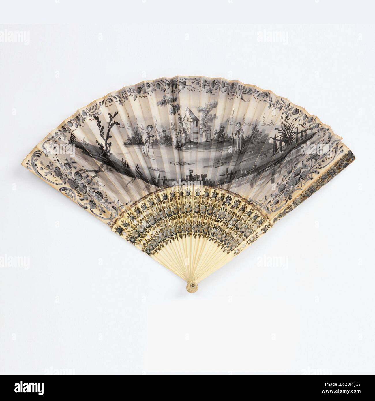 Pleated fan. Pleated fan. The paper leaf is painted in black and white gouache. On the obverse, a pastoral scene of two women and a boy in front of a house in a rural landscape, with floral borders. On the reverse, a small sketchy landscape with a house, in black. Stock Photo