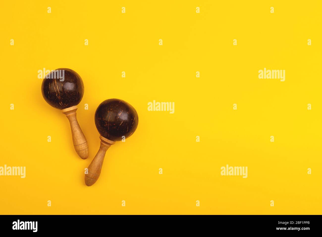 Two mexican maracas isolated on yellow background. Traditional folk musical instruments. Elements of national culture. Flat lay. Latin music. Stock Photo
