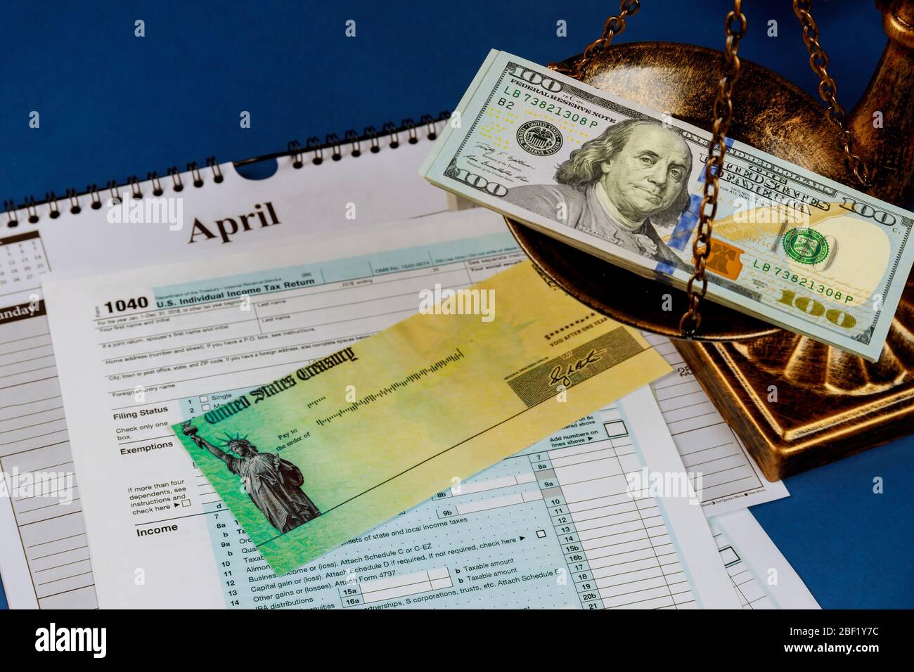 Individual Income Return Tax Law scales of justice criminal liability for non-payment of taxes of one hundred dollars bill form 1040 on U.S. Stock Photo