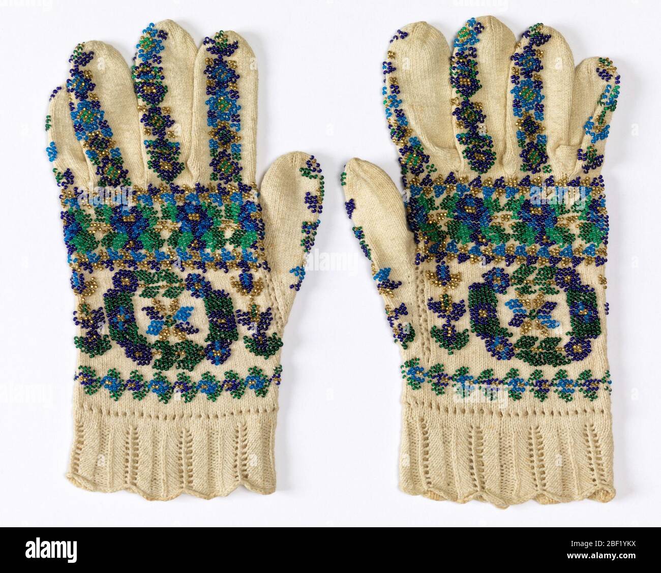 Gloves. Gloves ornamented with blue, green and gold beads in design of conventionalized flowers. Stock Photo