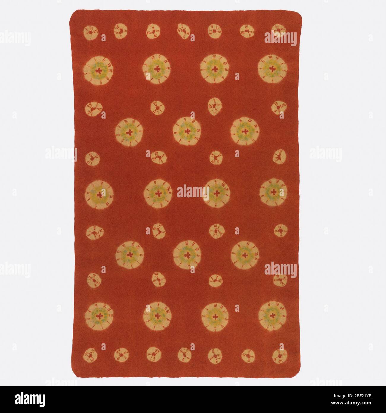Mosen. Rectangular rug made of wool which is felted, then patterned with tied resist dyeing, leaving large and small dots of yellow in a deep red-orange ground. Touches of green applied by brush. A mosen is a type of rug used in Japanese tea ceremonies. Stock Photo
