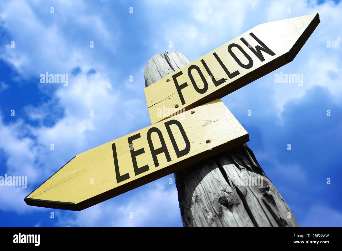 Lead, follow wooden signpost Stock Photo Alamy