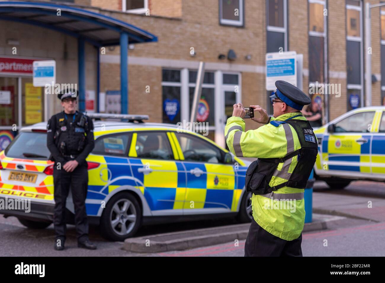 Police officers arriving at Clap for Carers outside Southend Hospital during the COVID-19 Coronavirus. Officer taking photograph for social media Stock Photo