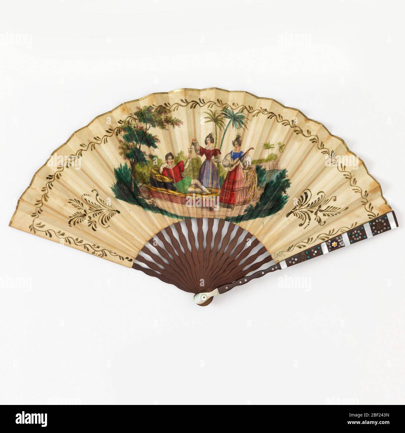 Pleated fan. Pleated folding fan with hand-colored etching and stipple engraved paper leaf with wood sticks and guards inlaid with steel discs, mother-of-pearl, steel discs, and stone ornaments. Stock Photo