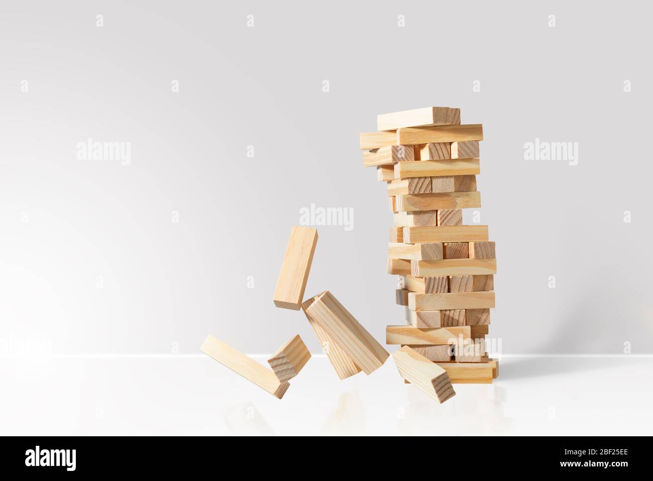 Wooden block tower game collapses isolated on white background with copy space Stock Photo